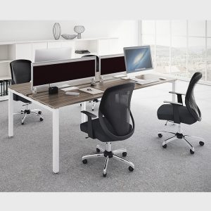 Escritorio de oficina con dos estaciones de trabajo y sillas ergonómicas negras en un entorno moderno.