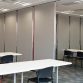 Muros móviles en un espacio de oficina con mesas y sillas dispuestas en el área.